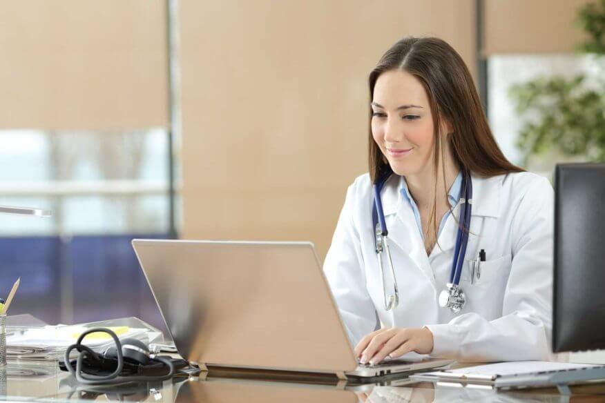 doctor looking at laptop in office