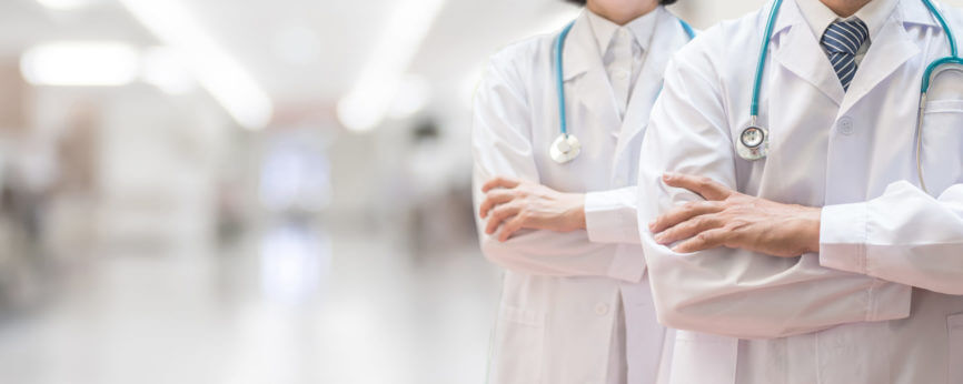 two doctors with stethoscopes folding their arms