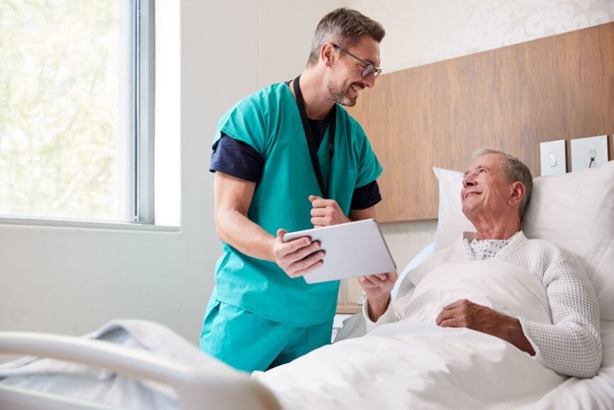 nurse talking to man in hospital bed