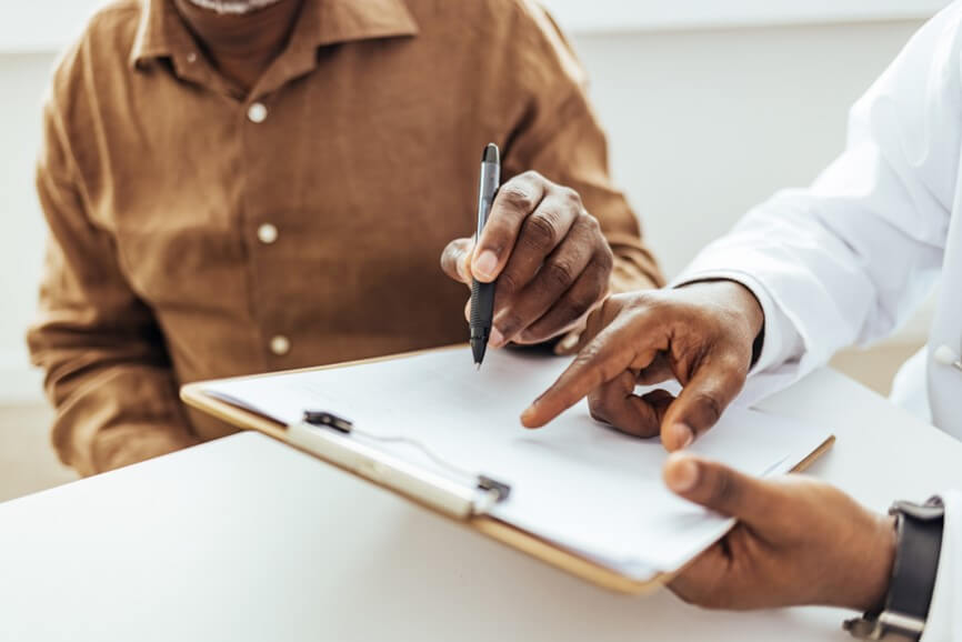 Doctor and patient using a pen to fill out a survey
