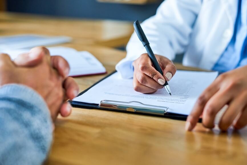 Two people at a table filling out medical worksheet
