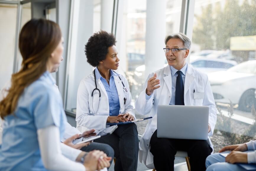 three doctors in room discussing something