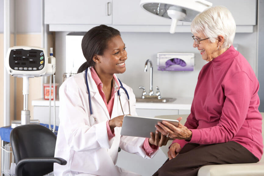 Clinician and patient holding an iPad in a clinic and smiling