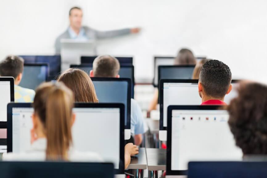Person teaching a class with listeners on computers