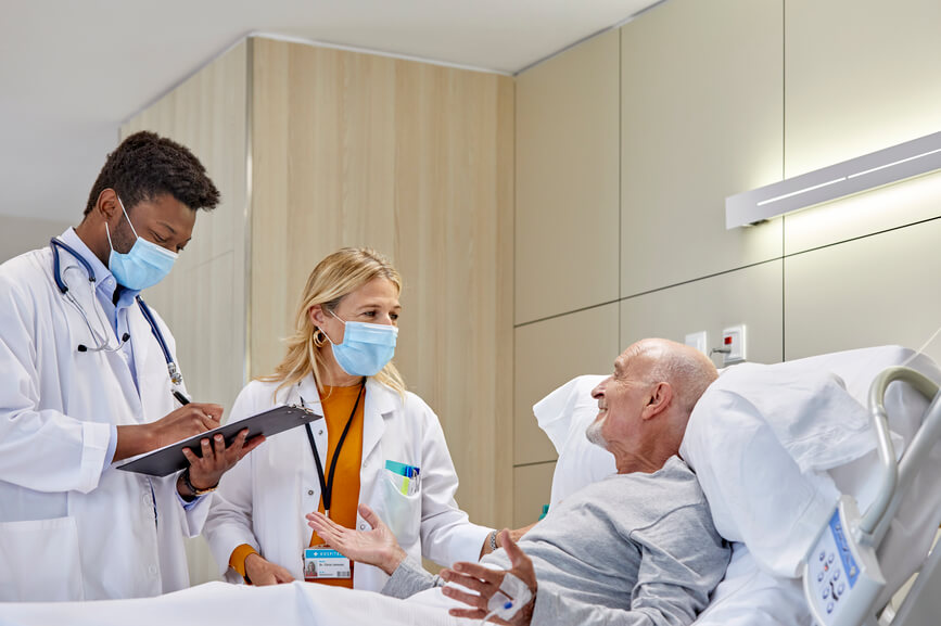 Doctors examining a senior patient in a hospital room