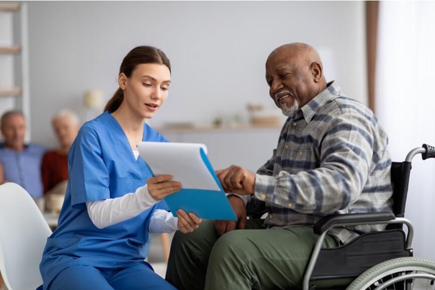 Nurse assisting man with survey on clipboard