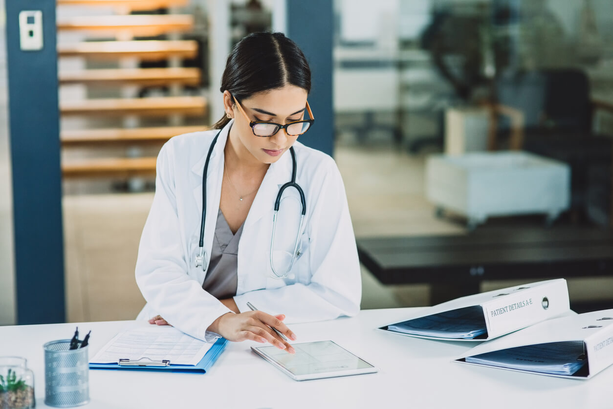 Doctor sitting at desk with tablet