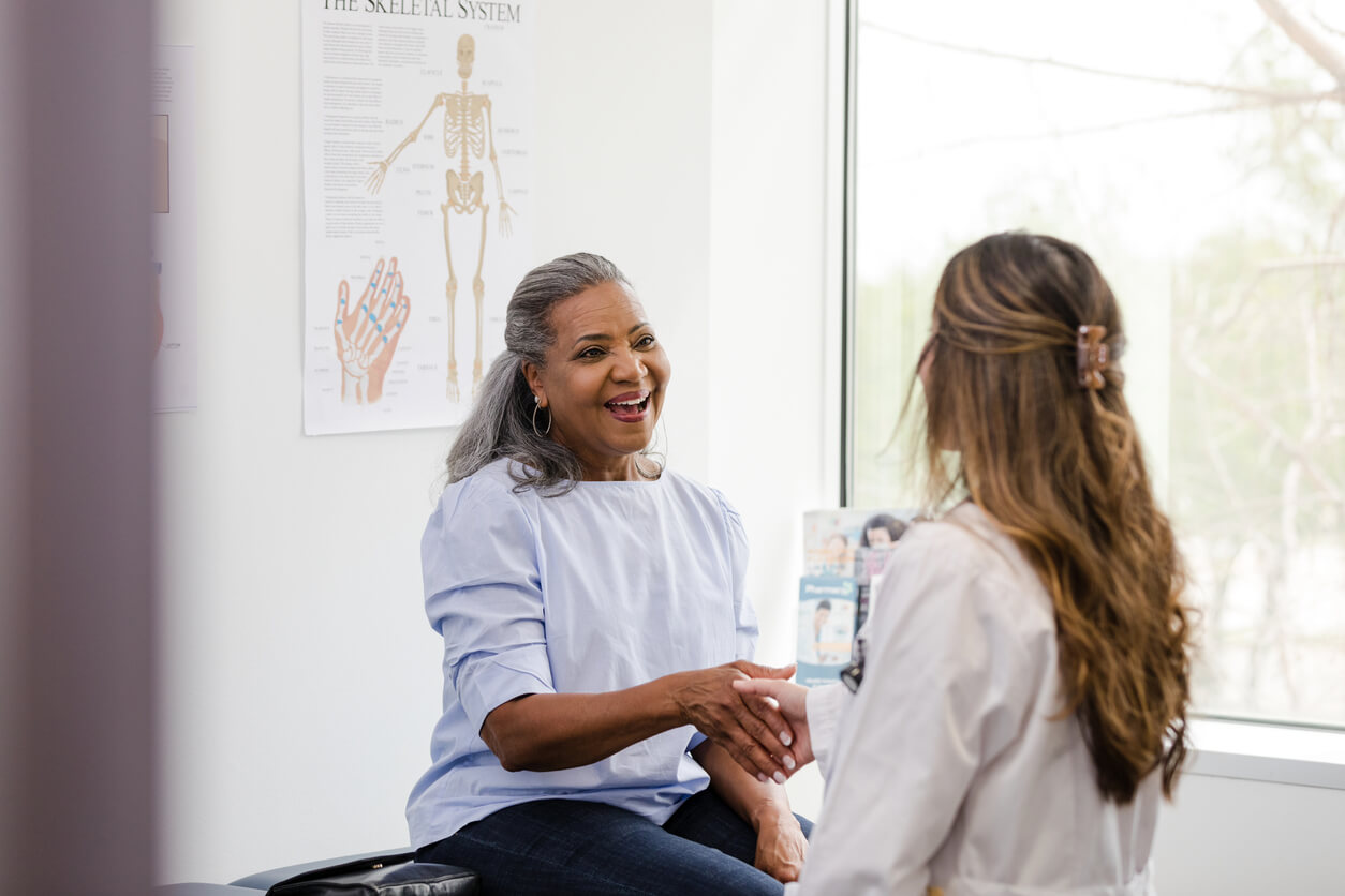 Female patient shakes hands with the female healthcare professional