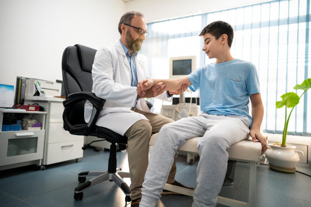 Doctor checks the condition of the boy's arm