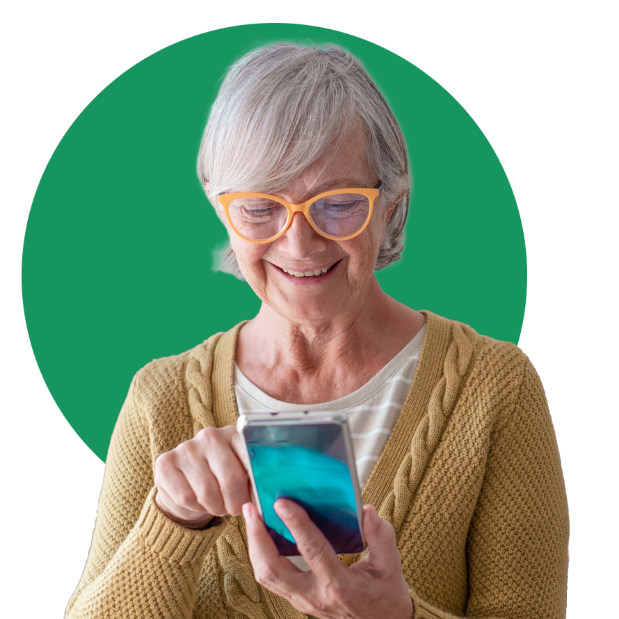 Smiling older woman with gray hair and orange glasses uses a smartphone, wearing a yellow cardigan, with a green circle background—illustrating how patient-reported outcome measures (PROMs) empower individuals to actively participate in their healthcare.